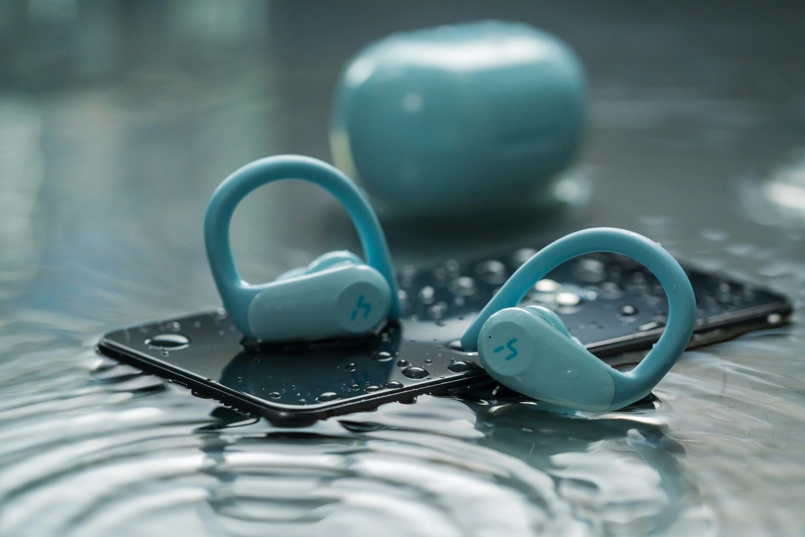 a pair of blue headphones sitting on top of a phone